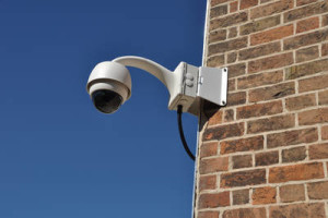 surveillance camera attached on a brick wall building